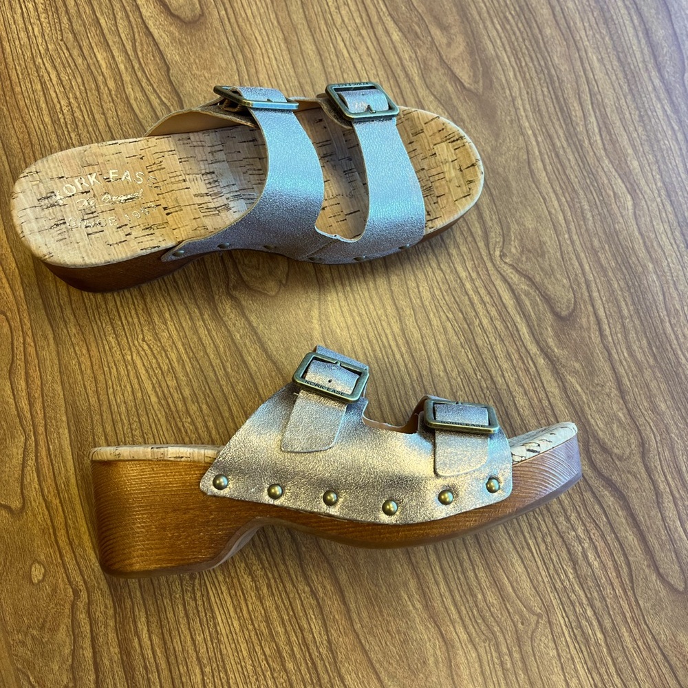 New, never worn. Very cute clog sandals. Color is a metallic platinum tone.